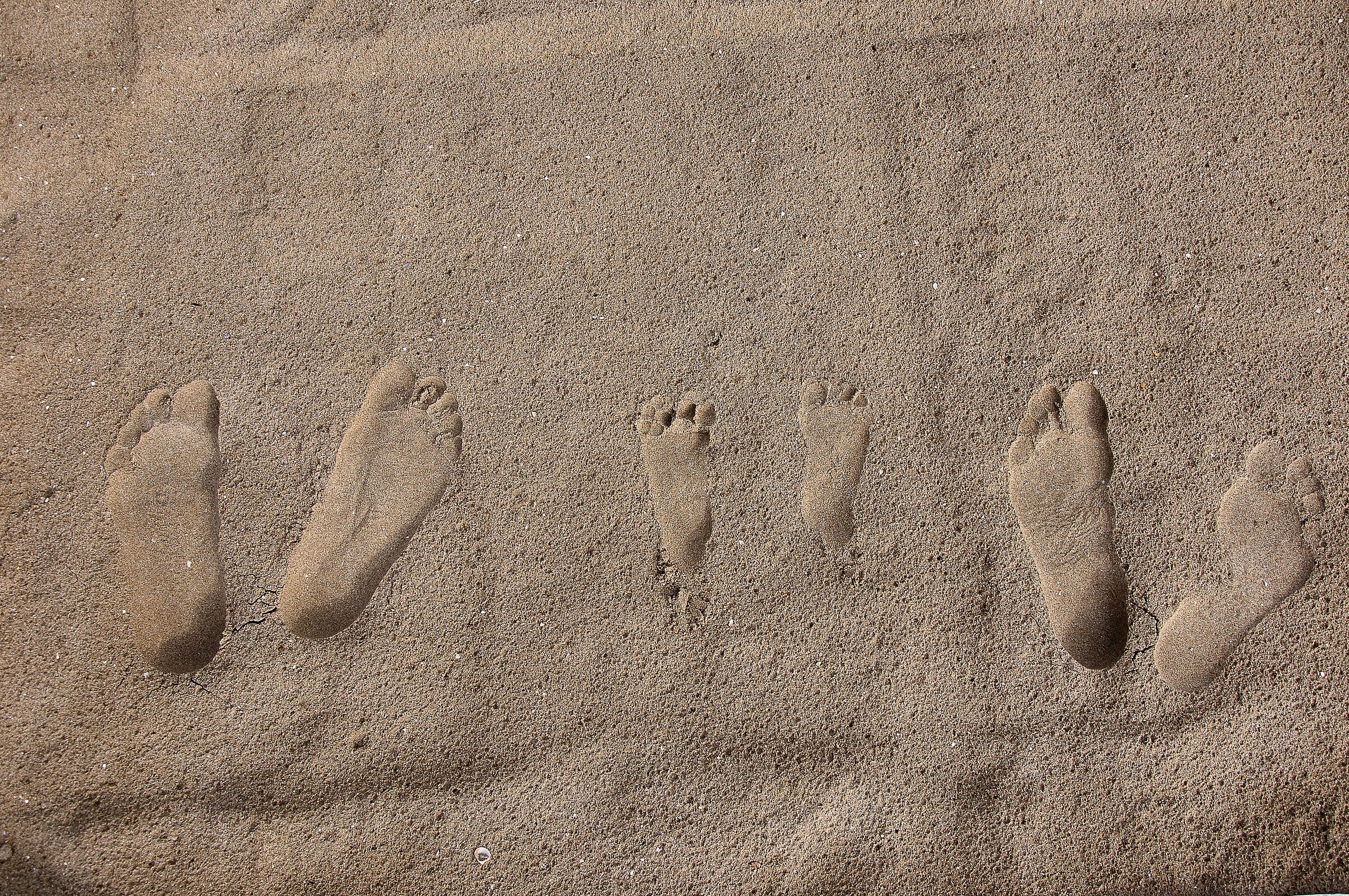 Zwei große und ein kleines Paar Fußspuren im Sand. Der BUND Naturschutz hat zahlreiche Materialien für die Umweltbildung zum Thema Sand. (Foto: zimmon/stock.adobe.com)