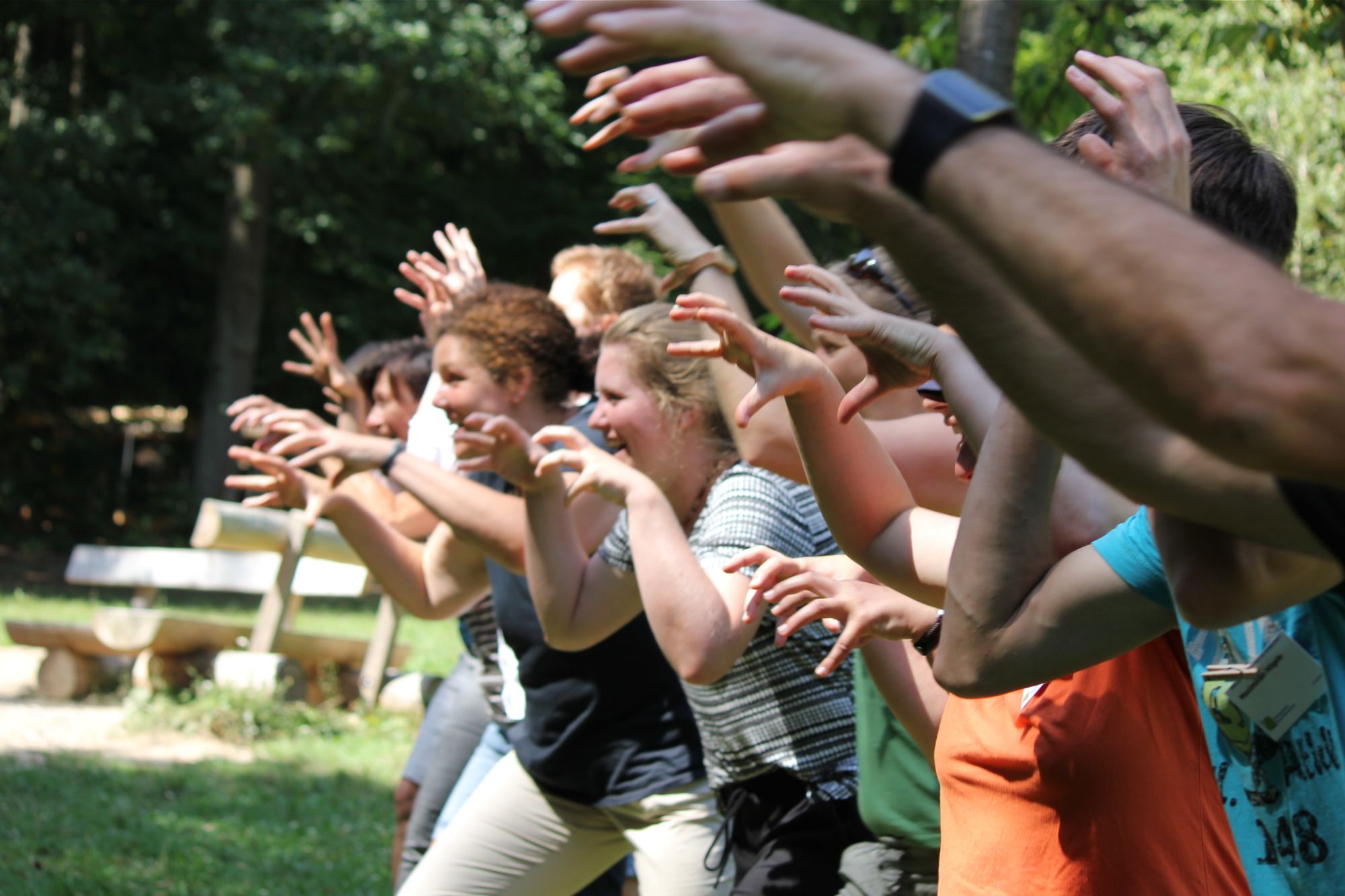 Eine Gruppe Menschen geht mit ausgebreiteten Armen auf eine andere zu. (Bild: Ulli Sacher-Ley)
