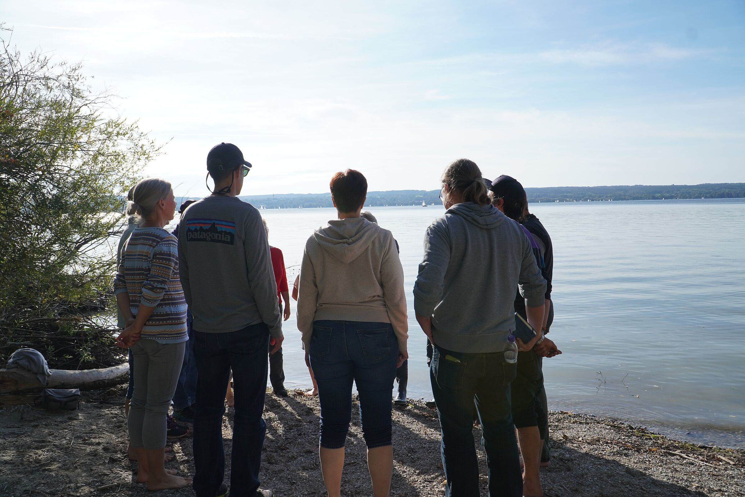 Eine Gruppe Menschen unterhält sich bei einem Workshop am Ufer des Ammersees (Bild: Maurice Rohmer)