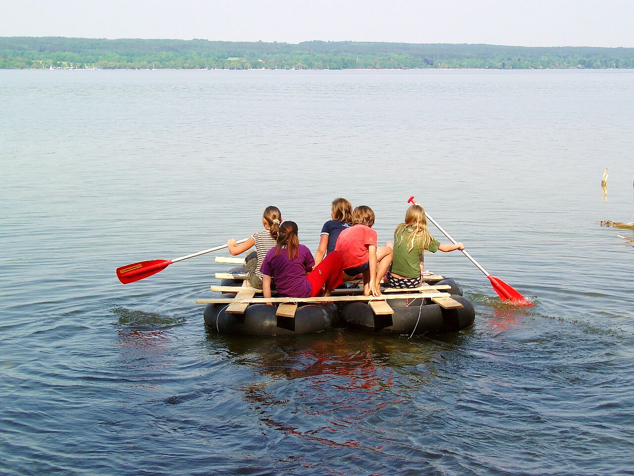 Eine Gruppe Jugendlicher fährt auf einem selbstgebauten Floß. (Bild: BN-Archiv)