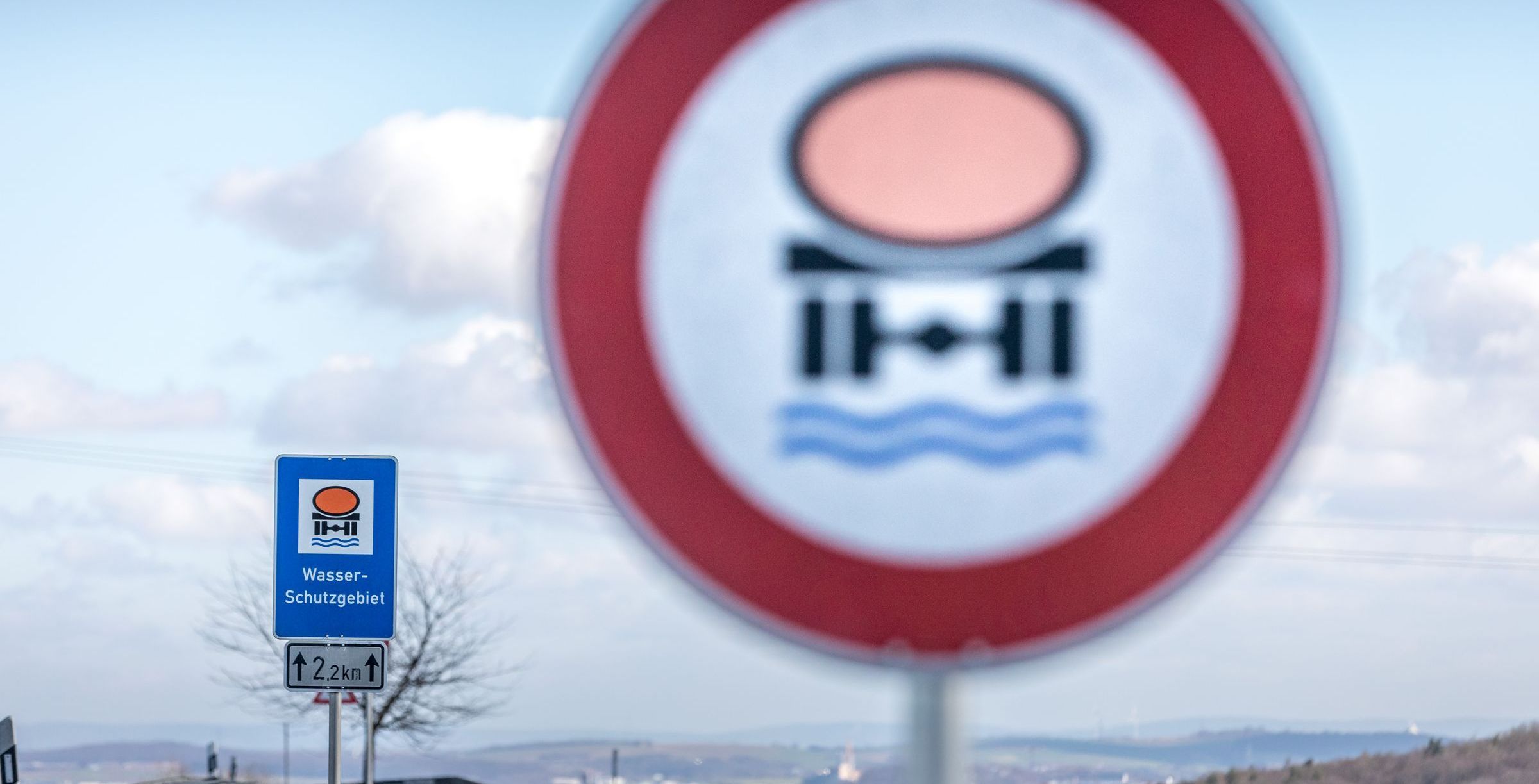 Verkehrsschilder zeigen ein Wasserschutzgebiet sowie das Verbot von Gefahrstoffen an, im Hintergrund die Alpen: 95 Prozent vom Trinkwasser Bayern stammen aus Grundwasserreservoirs, Wasserschutzgebiete sind für seine Reinheit extrem wichtig. (Foto: Patty Varasano) 