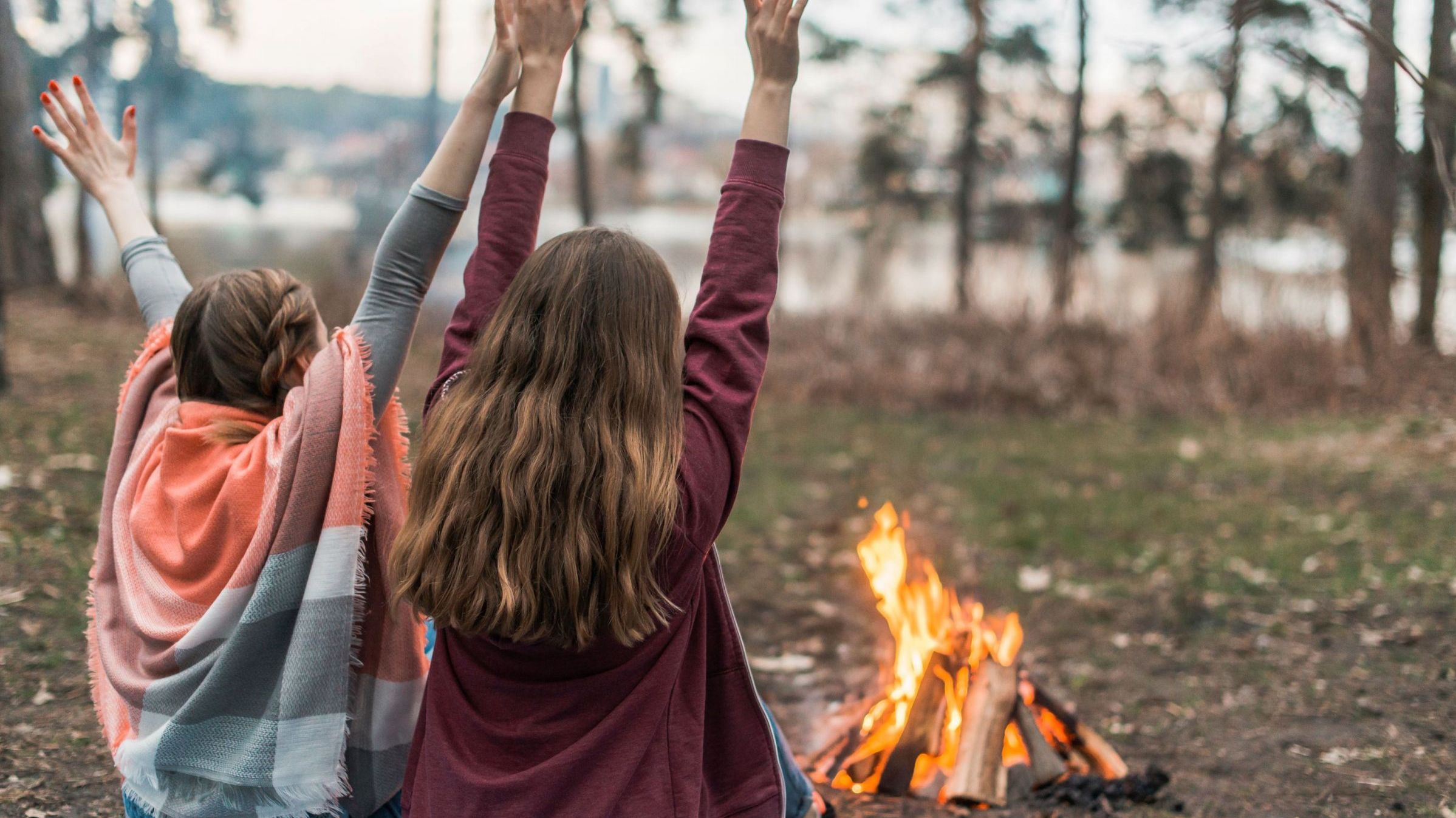 Zwei Kinder sitzen vor einem Lagerfeuer (Bild: freepick)