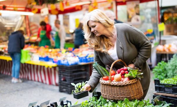 Eine Frau kauft Gemüse auf einem Wochenmarkt ein