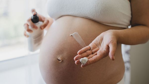 Schwangerschaft ohne Schadstoffe: Eine Schwangere cremt sich ihren gewölbten Bauch ein.