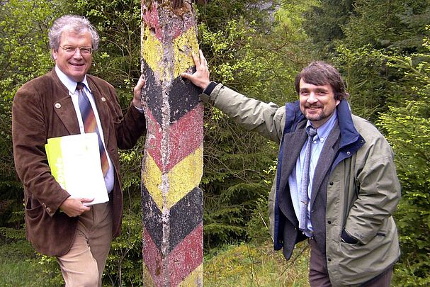 Am Grünen Band: Der ehemalige BN-Vorsitzende Hubert Weiger und der damalige BN-Artenschutzreferent Kai Frobel lehnen an einem schwarz-rot-gold gestrichenen Grenzpfosten der ehemaligen innerdeutschen Grenze. (Foto: BN e.V.)