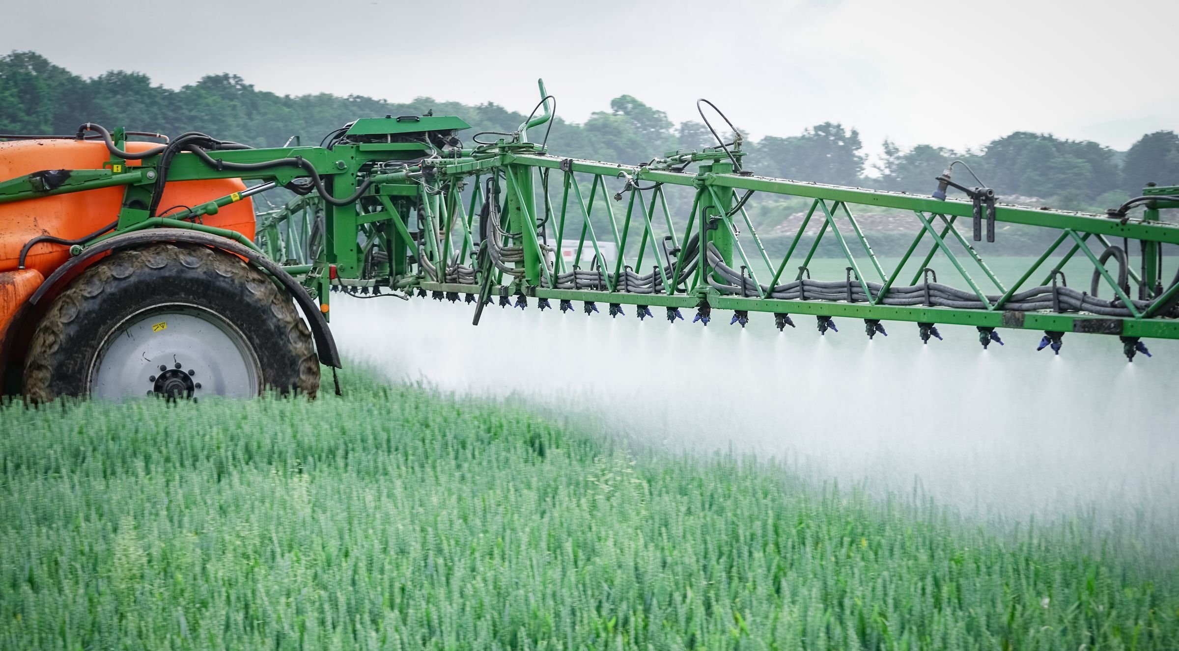 Ein Traktor, der auf einem Feld Pestizide ausbringt. Pflanzenvernichtungsmittel wie Glyphosat belasten die Umwelt stark. (Foto: countrypixel/stock.adobe.com)