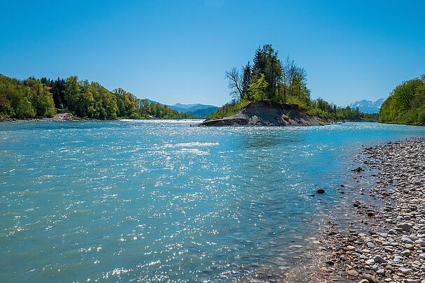 Zwei große Flüsse mit türkisfarbenem Wasser und bewaldeten Ufern fließen zusammen, im Vordergrund Kiesbänke, im Hintergrund schneebedeckte Berge. (Foto: naturenow/stock.adobe.com)