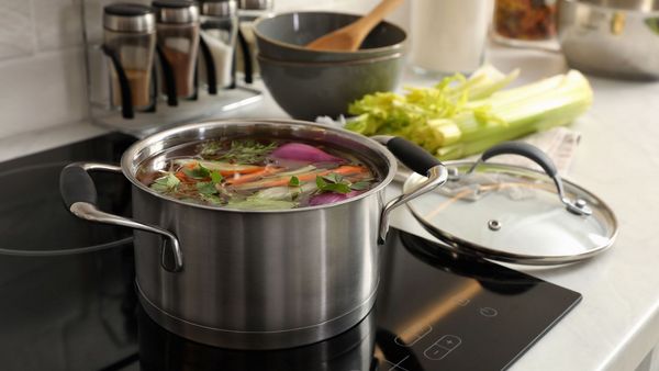 Lebensmittelverschwendung vermeiden: In einem Topf kochen Gemüsereste.