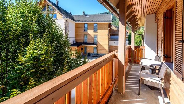 Nachhaltig wohnen mit Holz: Auf einem Balkon aus Holz stehen Möbel aus Holz.