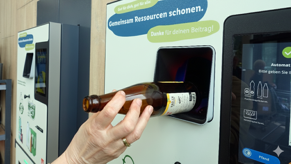 Altglas richtig entsorgen und trennen: Eine bringt eine Pfandflasche zurück ins Geschäft.