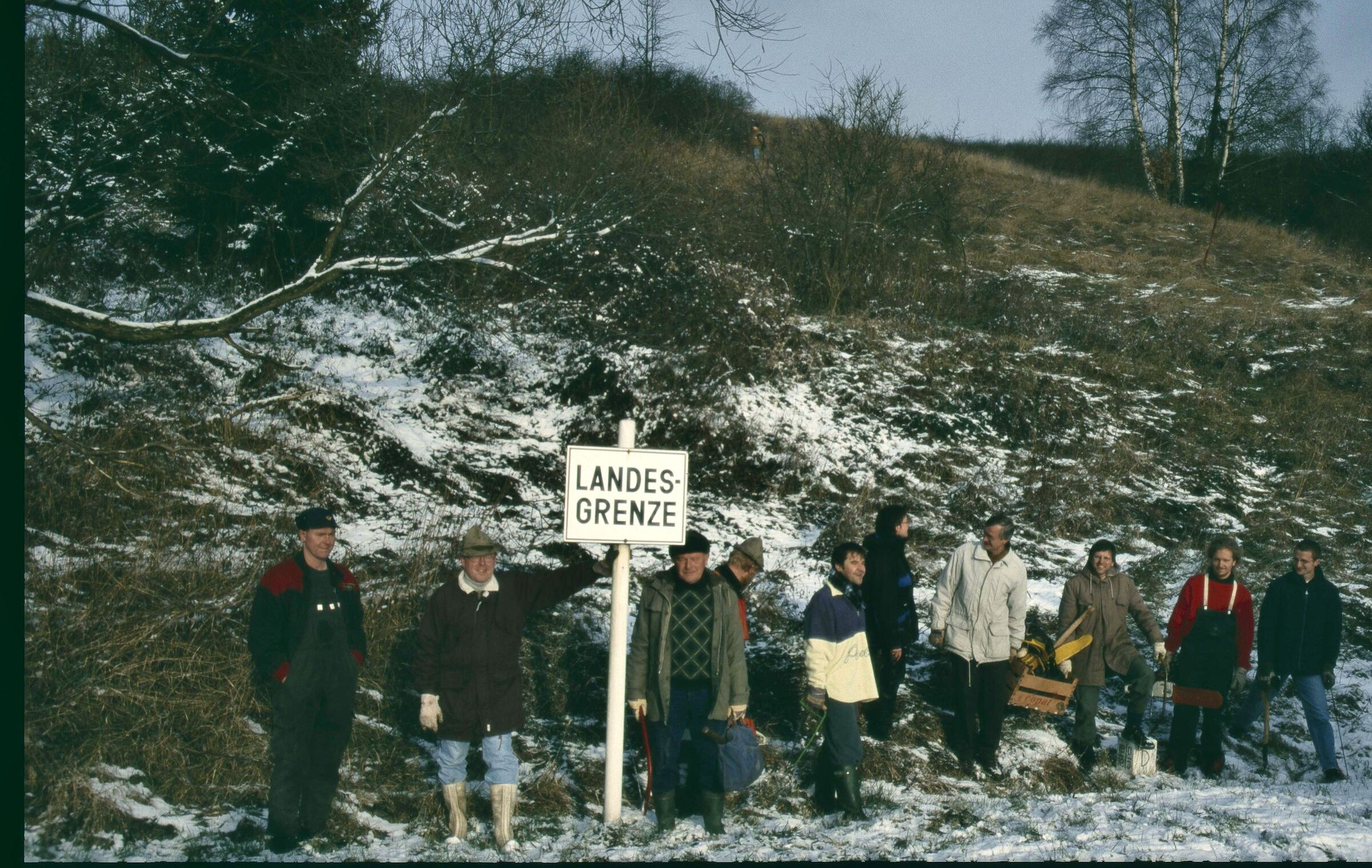 Grenzüberschreitender Arbeitseinsatz am Grünen Band: Aktive der Naturschutzverbände BN-Kreisgruppe Wunsiedel und CSOP Cheb stehen bei einem Grenzschild. (Foto: Karl Paulus) 