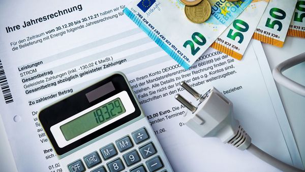 Tipps zum Energiesparen im Haushalt: Auf einem Brief mit der Jahresabrechnung für Strom liegen ein Taschenrechner und Euro-Scheine.